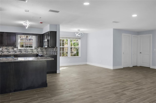 kitchen featuring tasteful backsplash, stainless steel microwave, visible vents, and a wealth of natural light