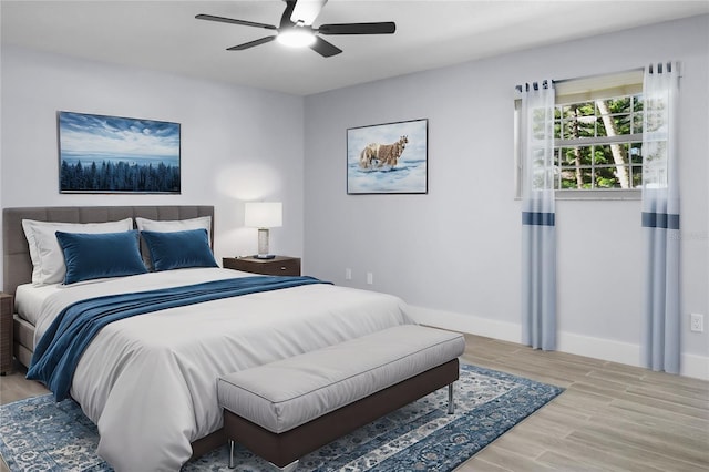 bedroom with ceiling fan, baseboards, and wood finished floors