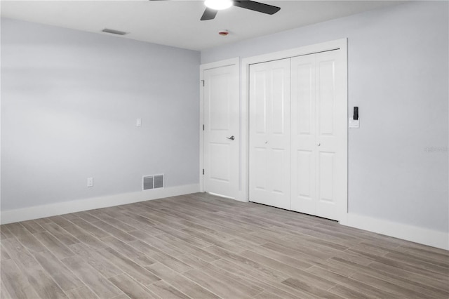 unfurnished bedroom featuring visible vents, a ceiling fan, a closet, light wood-style floors, and baseboards