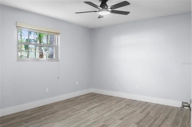 spare room featuring a ceiling fan, wood finished floors, and baseboards