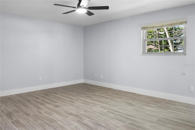 spare room with baseboards, a ceiling fan, and light wood finished floors