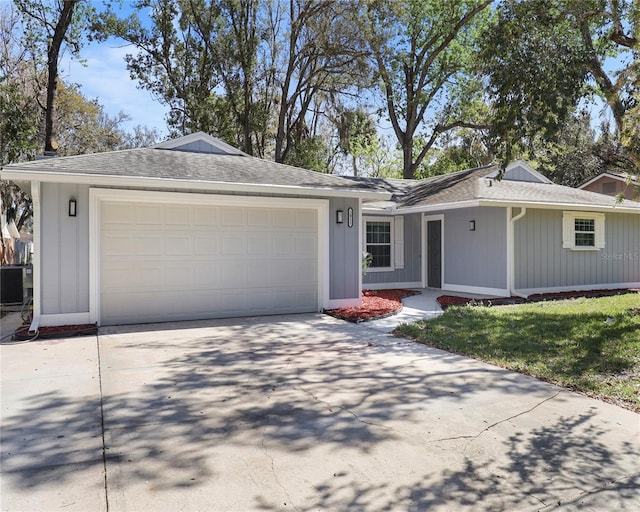 ranch-style home with concrete driveway, an attached garage, and roof with shingles