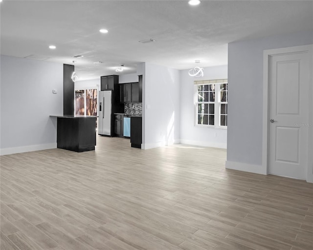 unfurnished living room featuring recessed lighting and light wood-type flooring