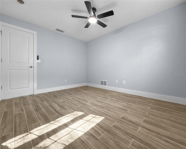 empty room featuring visible vents, ceiling fan, baseboards, and wood finish floors