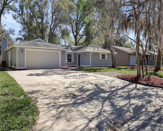 ranch-style home featuring driveway, central AC unit, and an attached garage