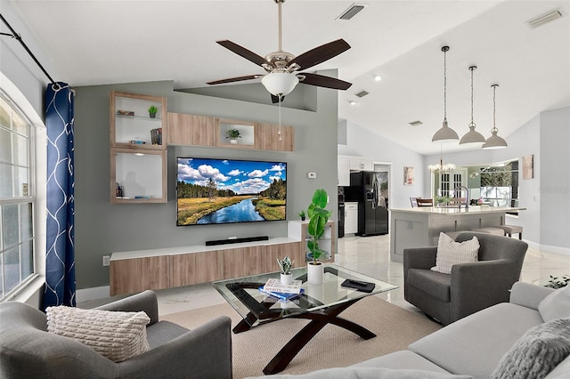 living room featuring ceiling fan with notable chandelier, visible vents, marble finish floor, and baseboards