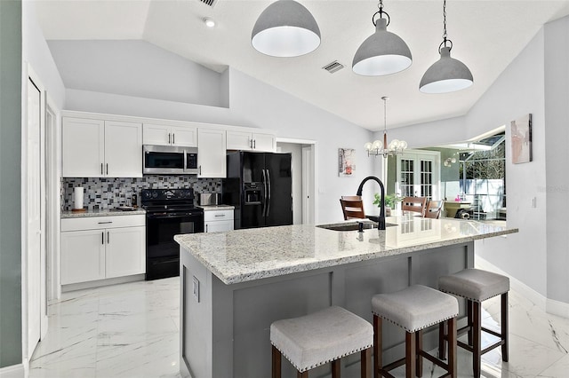 kitchen with visible vents, lofted ceiling, marble finish floor, black appliances, and a sink