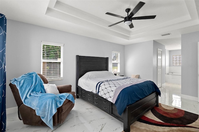 bedroom featuring a tray ceiling, multiple windows, and marble finish floor