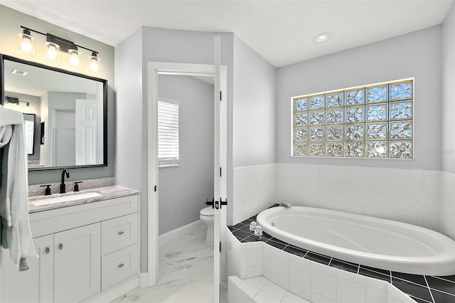 full bathroom featuring vanity, baseboards, a garden tub, toilet, and marble finish floor