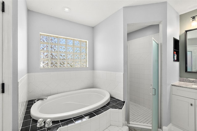 bathroom featuring vanity, a bath, and a shower stall