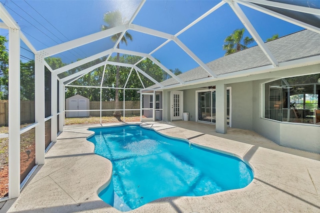 view of swimming pool with a storage unit, an outbuilding, a ceiling fan, a fenced backyard, and a patio area