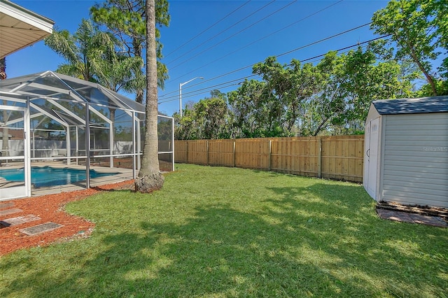 view of yard featuring glass enclosure, a fenced in pool, a fenced backyard, an outdoor structure, and a storage shed