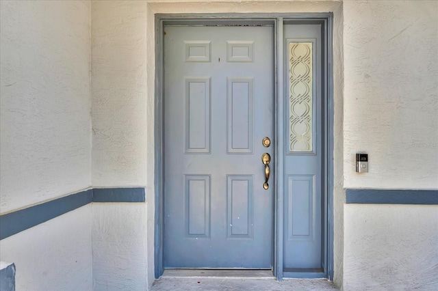 view of exterior entry with stucco siding