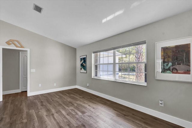 spare room with dark wood finished floors, baseboards, and visible vents