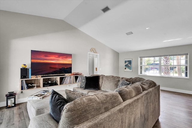 living room with vaulted ceiling, wood finished floors, visible vents, and baseboards