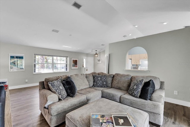 living room with visible vents, baseboards, and wood finished floors