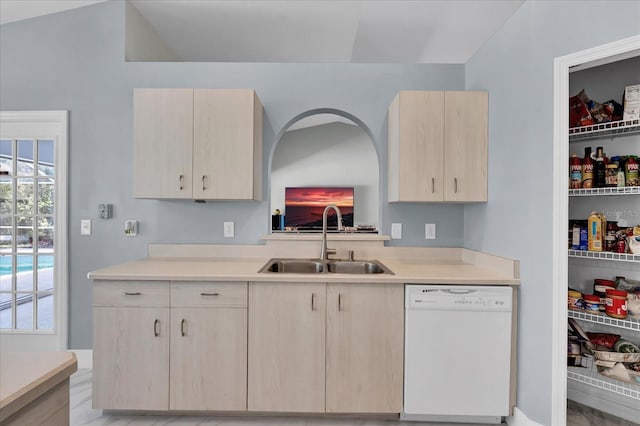 kitchen featuring a sink, light brown cabinets, and white dishwasher