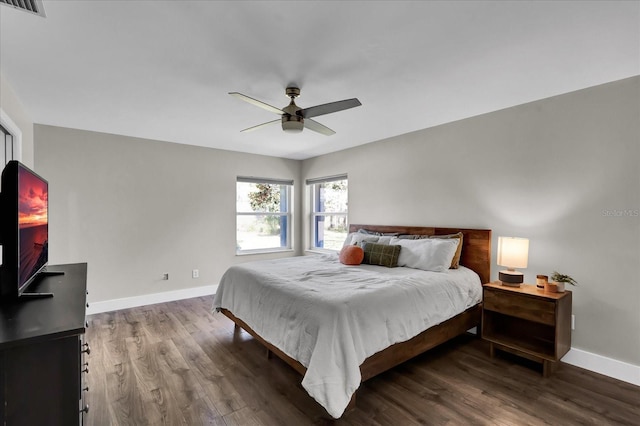 bedroom with visible vents, baseboards, wood finished floors, and a ceiling fan