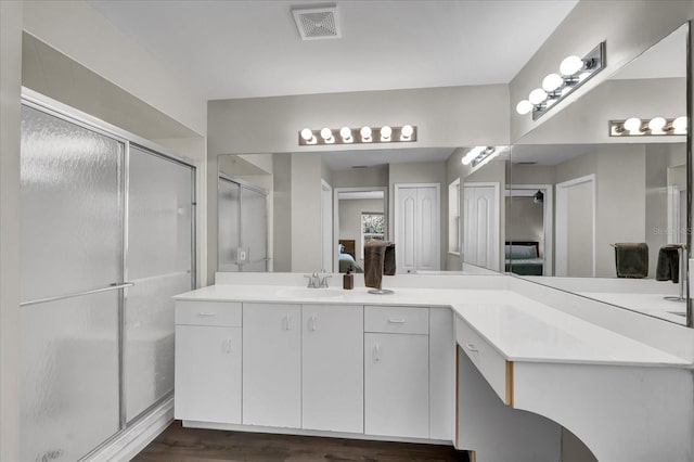 full bathroom featuring visible vents, a stall shower, vanity, and wood finished floors