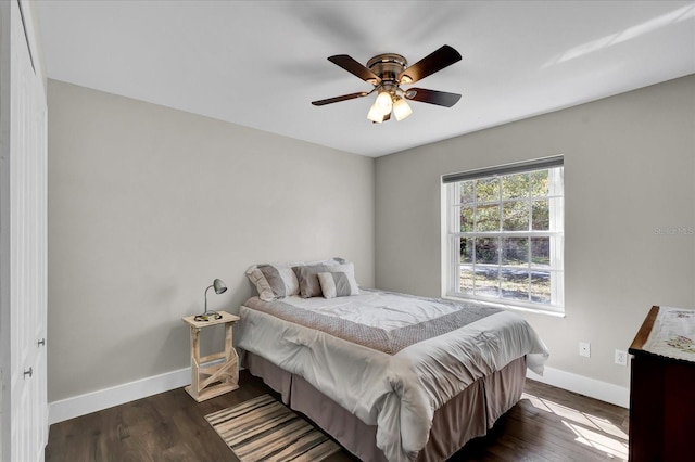 bedroom with a ceiling fan, baseboards, and dark wood-style flooring