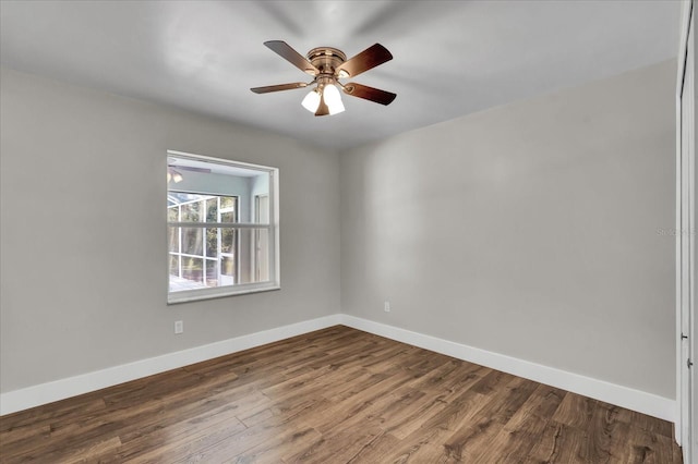 unfurnished room featuring dark wood-type flooring, baseboards, and ceiling fan