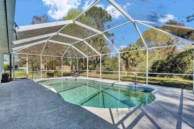 outdoor pool featuring glass enclosure and a patio area