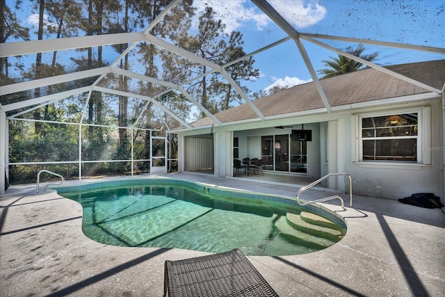 pool featuring glass enclosure and a patio