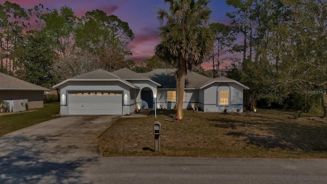 ranch-style house featuring driveway, a lawn, and an attached garage