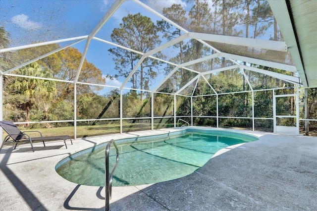 outdoor pool with glass enclosure and a patio