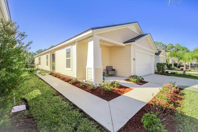 view of side of property featuring concrete driveway and an attached garage