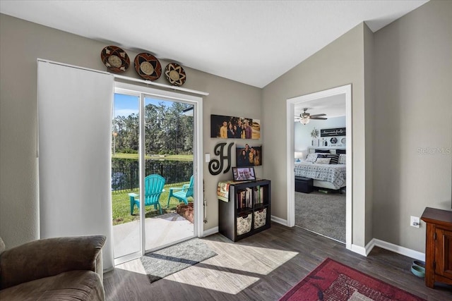 doorway featuring baseboards, lofted ceiling, dark wood-type flooring, and a ceiling fan