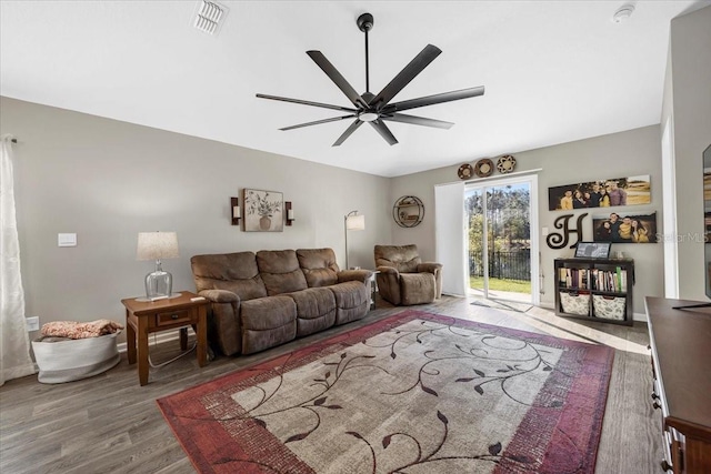 living area featuring visible vents, baseboards, ceiling fan, and wood finished floors