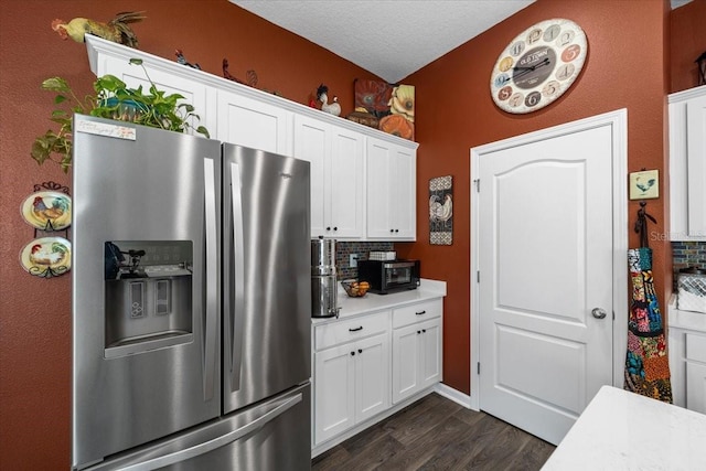 kitchen with stainless steel fridge, white cabinetry, dark wood-type flooring, and light countertops