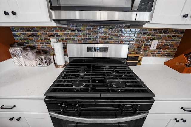 room details with white cabinetry, tasteful backsplash, and appliances with stainless steel finishes