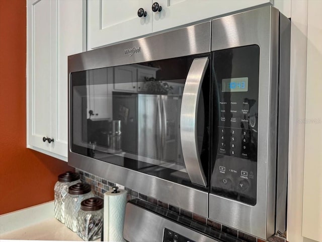 room details featuring stainless steel microwave and white cabinetry