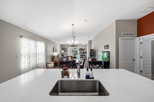 kitchen with visible vents, a notable chandelier, a sink, plenty of natural light, and open floor plan