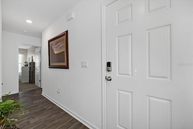 hall featuring baseboards and dark wood finished floors