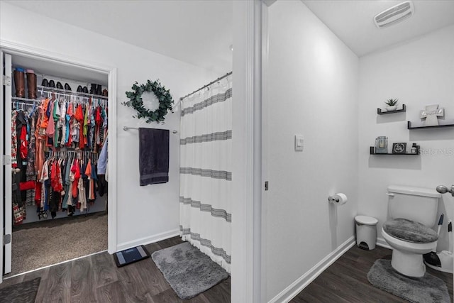 bathroom with visible vents, toilet, baseboards, and wood finished floors