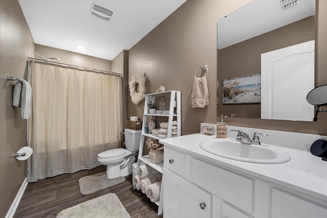 bathroom with visible vents, toilet, wood finished floors, and vanity