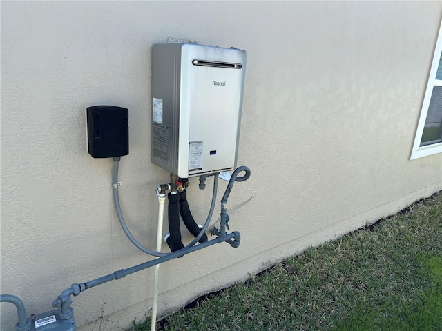 details featuring tankless water heater and stucco siding