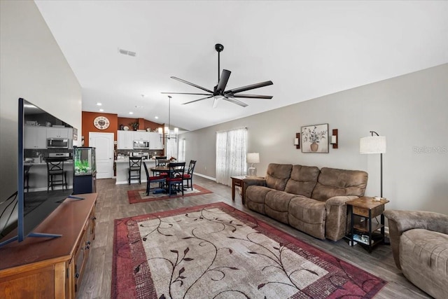 living area featuring visible vents, dark wood finished floors, lofted ceiling, recessed lighting, and ceiling fan