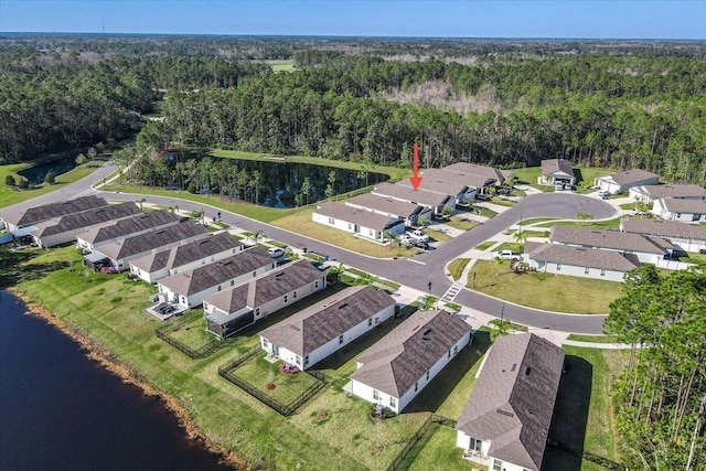 drone / aerial view featuring a residential view, a view of trees, and a water view