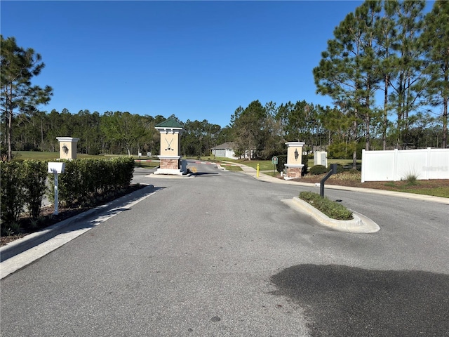 view of road featuring curbs and a gated entry