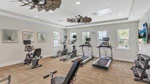 workout area featuring a raised ceiling and baseboards