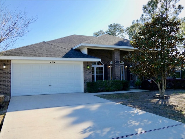 ranch-style house with driveway, brick siding, roof with shingles, and an attached garage