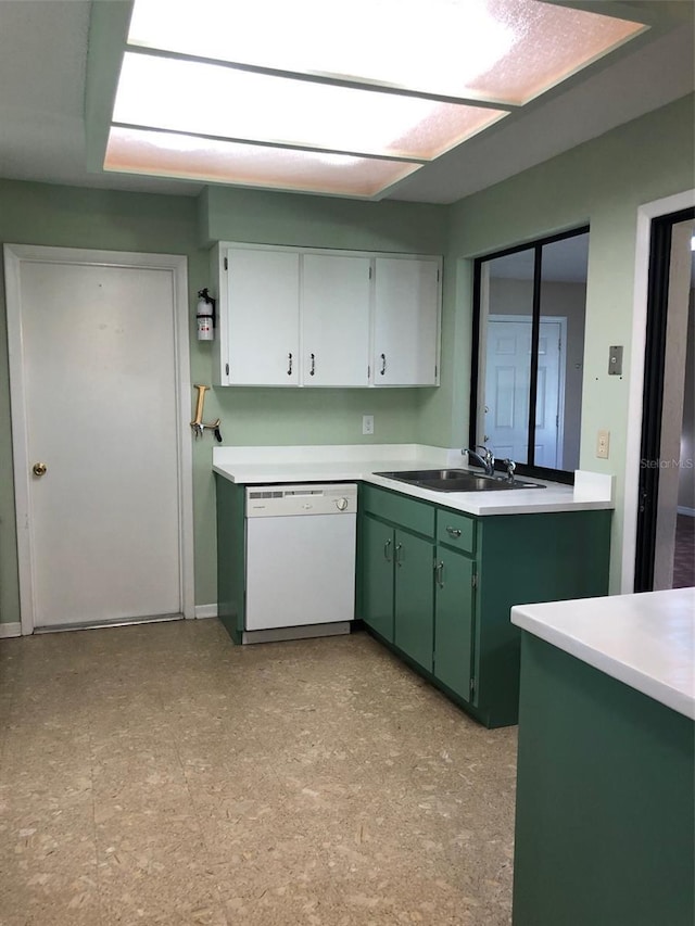 kitchen with a sink, green cabinets, white dishwasher, light countertops, and light floors