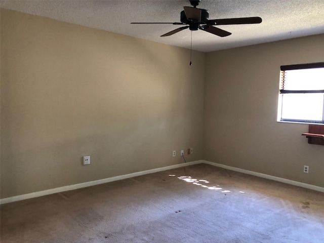 carpeted spare room with baseboards, a textured ceiling, and ceiling fan