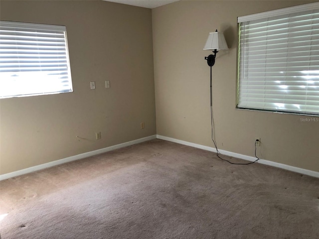 spare room with baseboards and carpet flooring