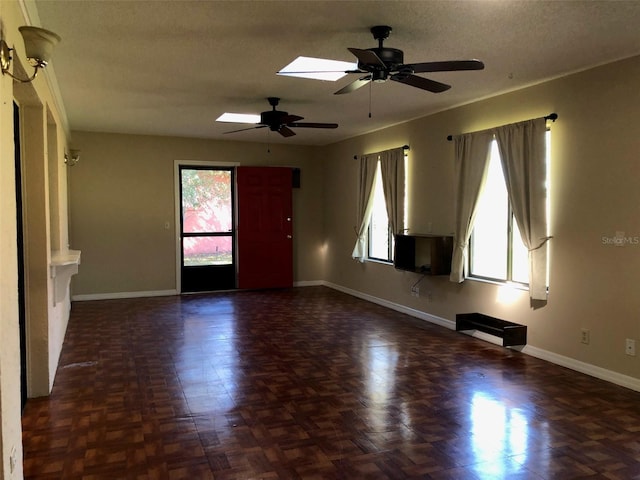 empty room with a wealth of natural light and baseboards