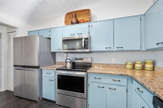 kitchen with ornamental molding, blue cabinetry, dark wood finished floors, stainless steel appliances, and lofted ceiling